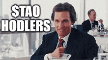 a man in a suit and tie is sitting at a table with the words stao hodlers written on it