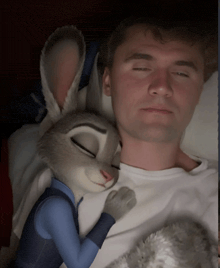 a man is sleeping with a stuffed bunny rabbit on his chest