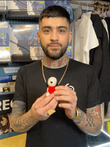 a man in a black shirt is holding a teddy bear in front of a sign that says indie