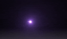 a bright purple light is shining in the dark .