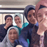 a group of women in hijab are laughing together