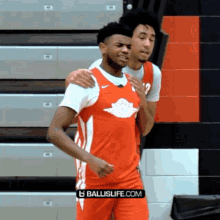 two basketball players standing next to each other with the ballislife.com logo in the corner