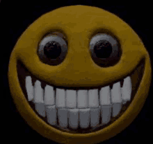 a close up of a smiley face with big teeth and big eyes .