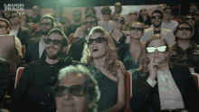 a group of people wearing 3d glasses are watching a movie with laugh track written on the bottom right