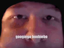 a close up of a man 's face with googlego boobiebo written on the bottom