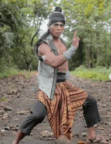 a man in a traditional costume is standing in a karate pose .