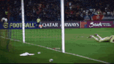 a soccer field with a qatar airways banner behind it