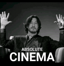 a black and white photo of a man with his hands in the air and the words absolute cinema behind him
