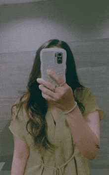 a woman taking a picture of herself with her phone