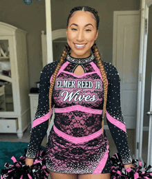 a cheerleader for elmer reed jr wives is smiling and holding pom poms