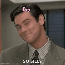 a man in a suit and tie is smiling and wearing a hello kitty hair clip .