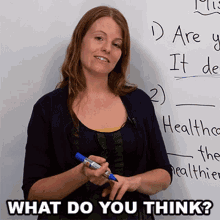 a woman holding a marker in front of a white board with the words what do you think written on it