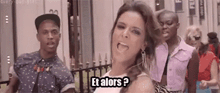 a woman is standing in front of a crowd of people and says et alors ?