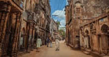 a group of people walking down a narrow street with a sign that says 42