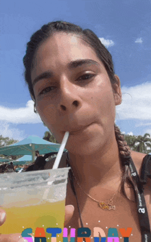 a woman drinking through a straw with saturday written on the bottom