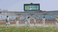 a group of young men are dancing on a field in front of a scoreboard that says final match 2 vs 3