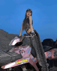 a woman is sitting on a pink atv with a sticker that says " ring me "