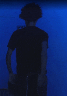 a person standing in front of a blue wall