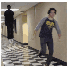 a man is jumping in the air in a hallway while another man runs behind him .