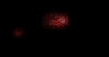 a dark room with a red glowing object in the corner