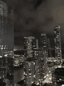 a view of a city at night with a few buildings including one that says ' allianz ' on it