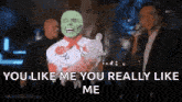 a man in a mask is standing in front of a crowd and says `` you like me you really like me ''