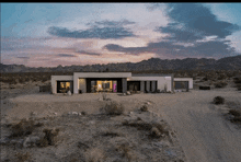 an aerial view of a house in the desert at sunset