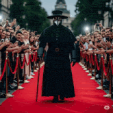 a man in a plague doctor costume is walking down a red carpet