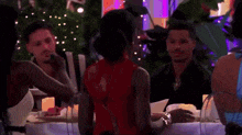 a group of people sitting at a table with candles on it