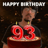 a man with glasses is blowing out candles on a cake that says 93