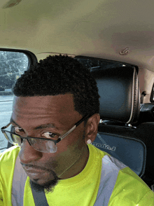 a man wearing glasses sits in the back seat of a dodge ram truck