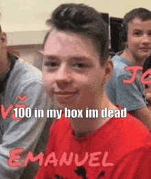 a boy in a red shirt with the name emanuel on it is sitting in a classroom with other students .