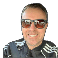 a man wearing sunglasses and a black adidas jacket