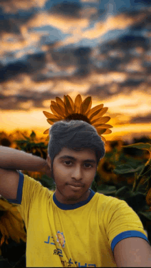 a boy with a sunflower on his head wearing a yellow shirt that says j.r.t.