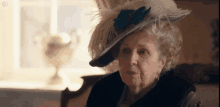 an elderly woman wearing a feathered hat and a fur collar