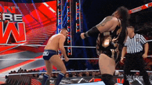 two men are wrestling in a wrestling ring with a referee standing behind them
