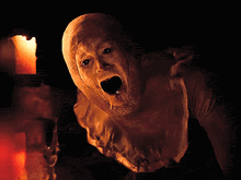 a pixel art of a monster with a candle behind it