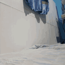 a blue shirt hangs on a white tiled wall