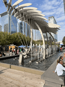 a fountain in the middle of a city with a lot of people around it