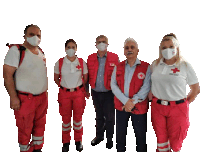 a group of people wearing masks and red vests with a cross on them