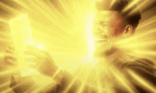 a man is holding a piece of paper in front of a bright yellow light .