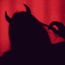 a shadow of a woman with horns on her head .