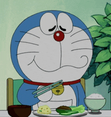 doraemon is sitting at a table with a plate of food and chopsticks