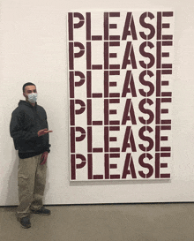 a man wearing a mask stands in front of a painting which says please