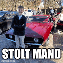 a young man stands in front of a red car with the words stolt mand on the bottom