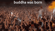 a crowd at a concert with the words buddha was born on the top