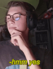 a man wearing glasses and headphones says hmm yes