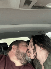 a man and a woman are kissing in the back seat of a car with the word climate on the roof