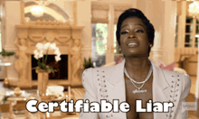 a woman says " certifiable liar " in front of a fireplace in a living room