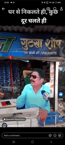 a man in sunglasses is standing in front of a store with a sign that says ' t ' on it .